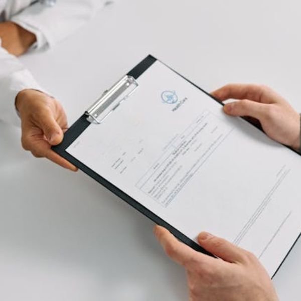 Profesional de la salud entregando un documento médico a un paciente